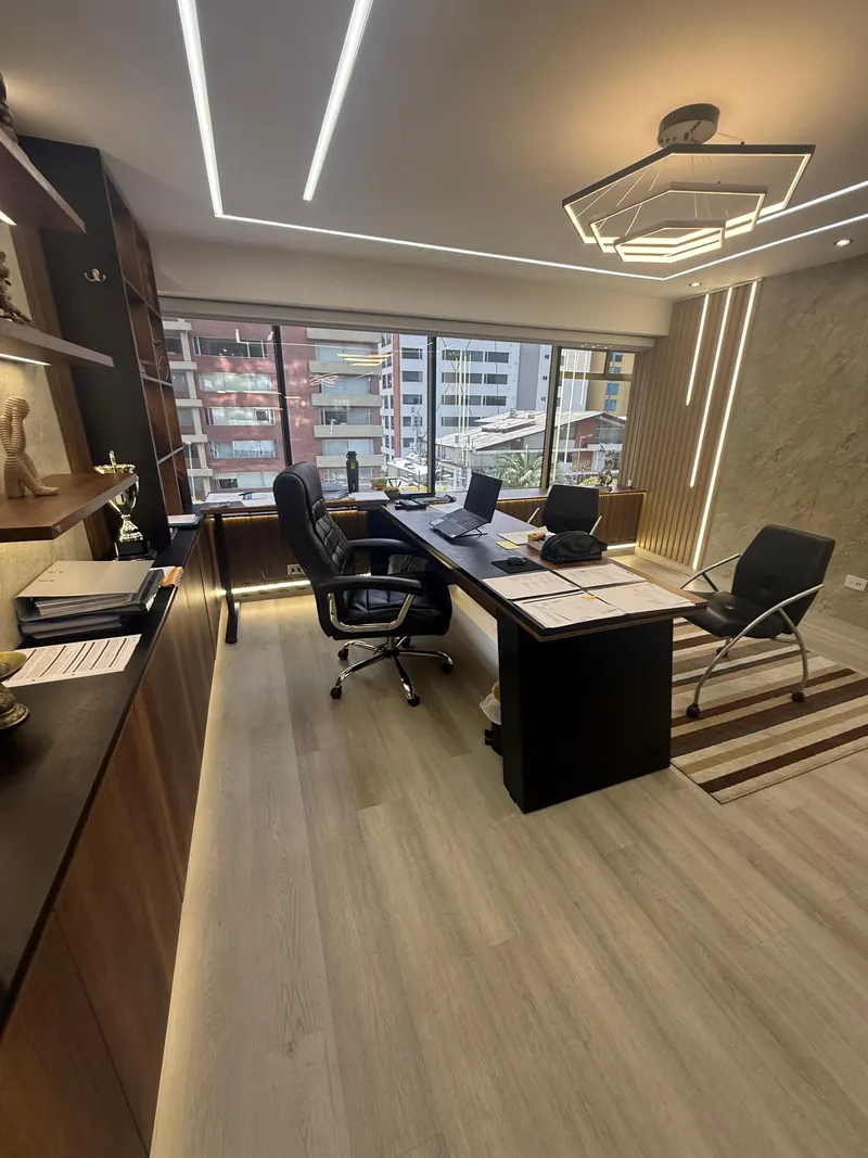Despacho con mesa de trabajo y ventanal, con luz lineal en el techo