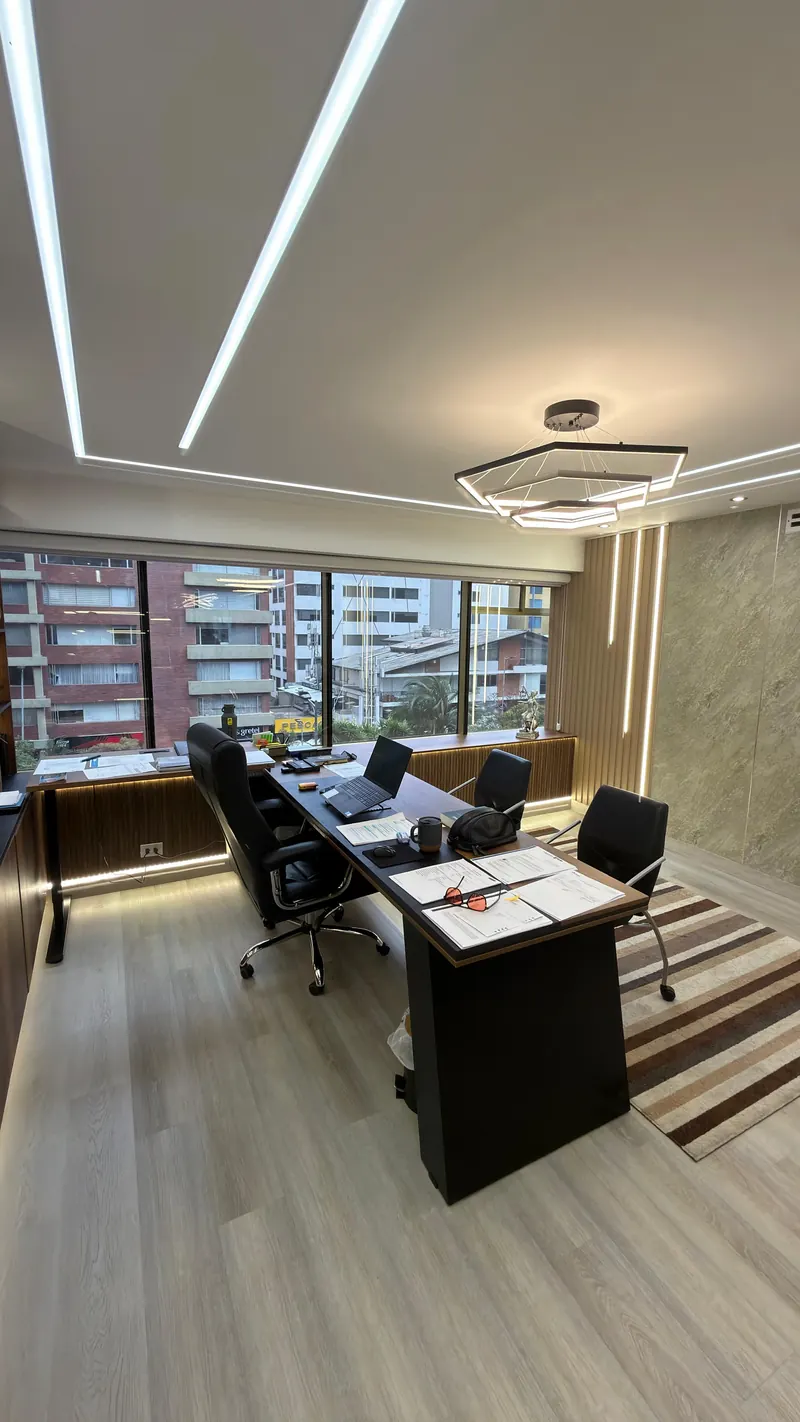 Despacho con mesa de trabajo, ventanal y luminaria hexagonal