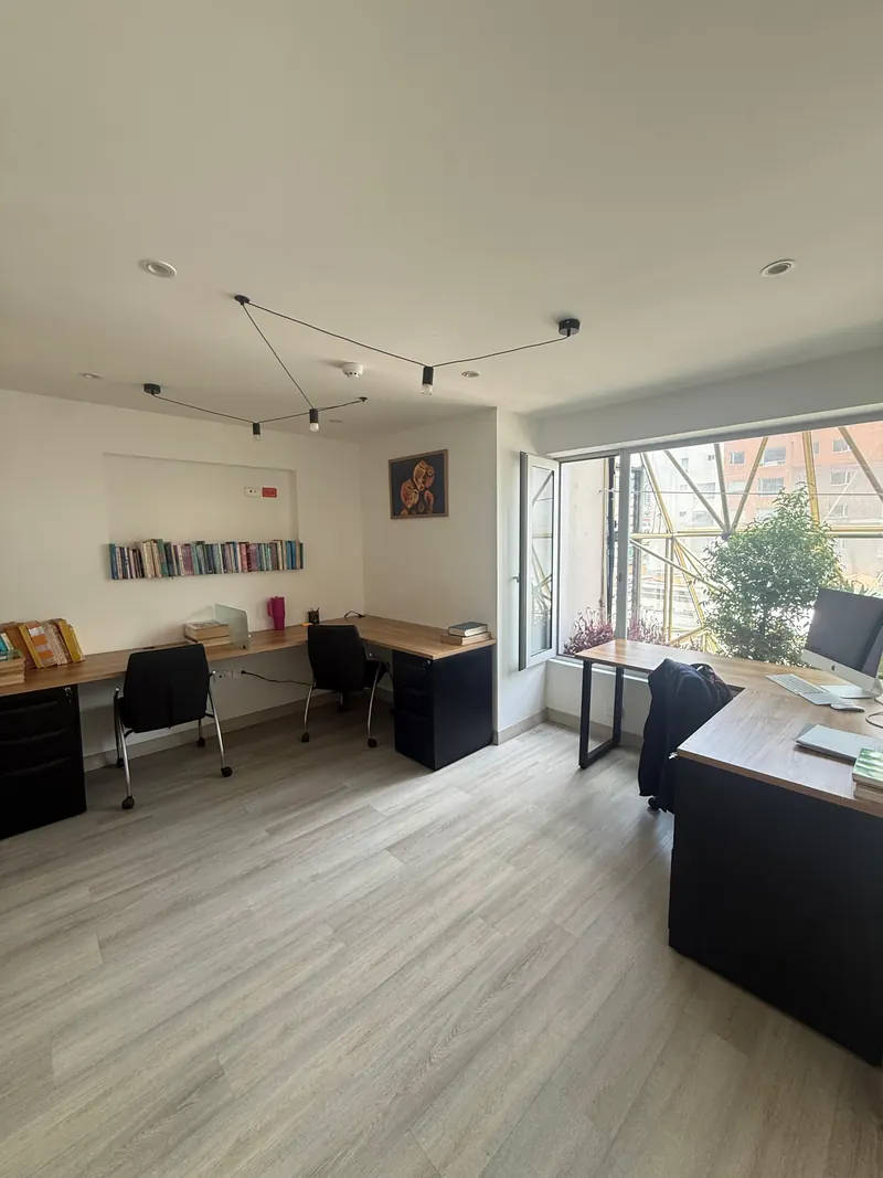 Oficina luminosa con escritorios junto a los ventanales